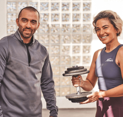 NASM Trainer Holding Dumbell Standing with Client